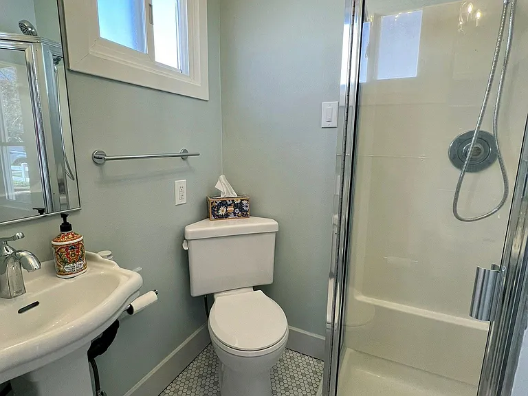 Freshly renovated bathroom with new sink, toilet, porcelain tile floor, and paint