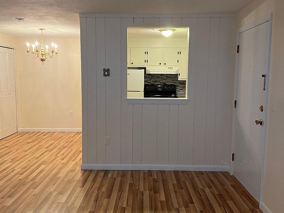 View from living room looking at the front door on right and kitchen in front