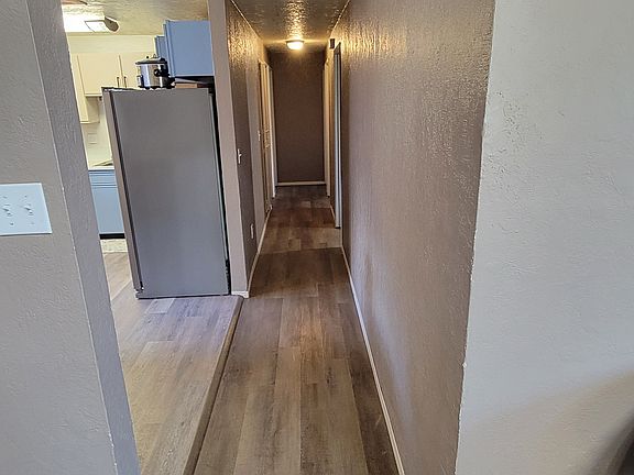 Hallway to bedrooms/bath with kitchen off to the left.