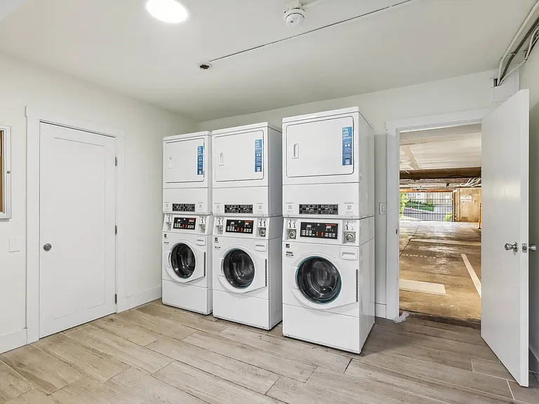 Laundry room with washing machines neatly arranged on a wooden floor