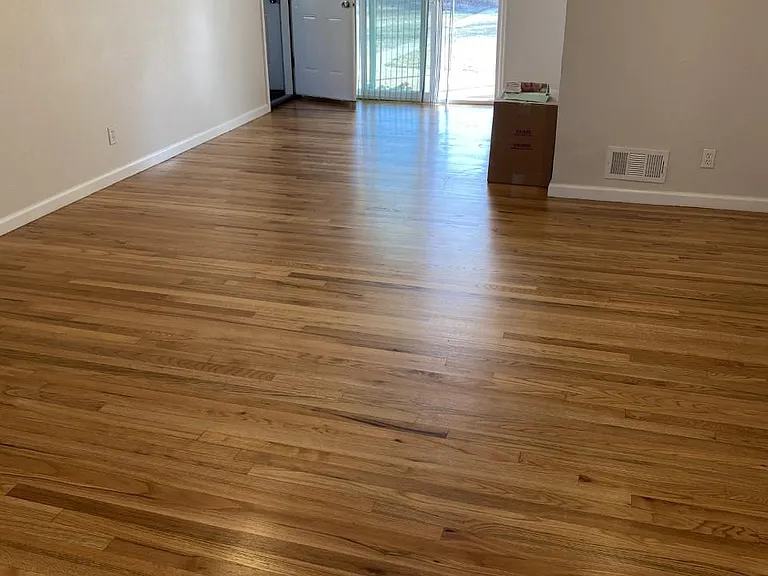 Photo taken from living room looking toward doors to patio and to garage; nice wood floors