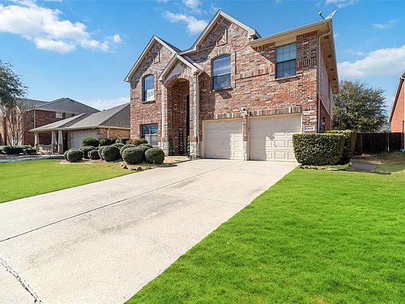 Traditional home with brick siding, driveway, and an attached garage