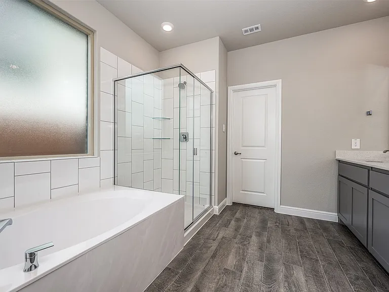 Bathroom with vanity, hardwood / wood-style flooring, and plus walk in shower