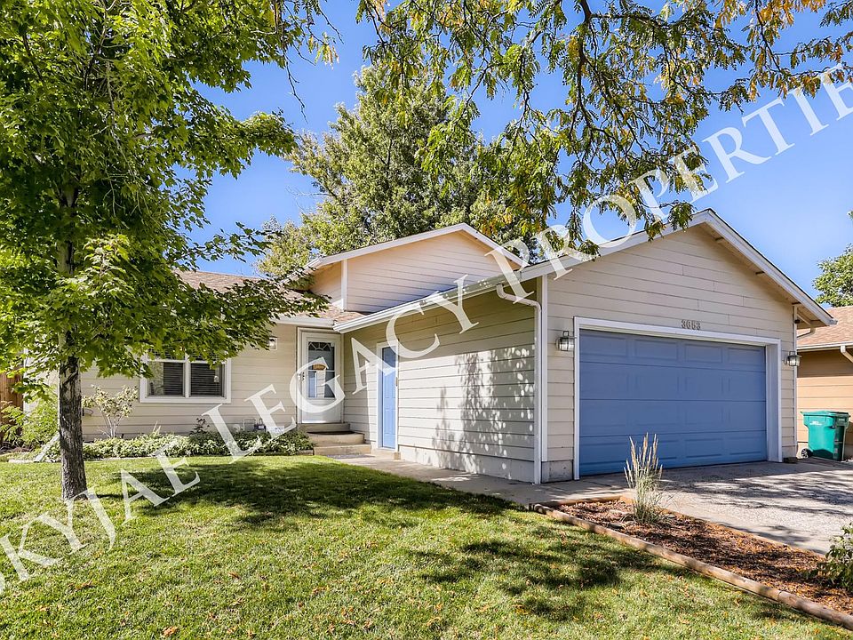 Exterior front of house with 2 car garage and mature trees.