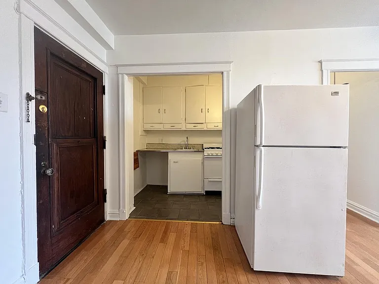 Galley kitchen includes refrigerator and gas range.