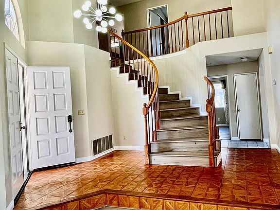 Entrance with high ceiling and open view with wood floor that leads to down stair bedroom, full bathroom, dining room and kitchen!