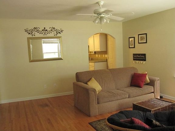 Living room with arched doorways & original hardwood floors.