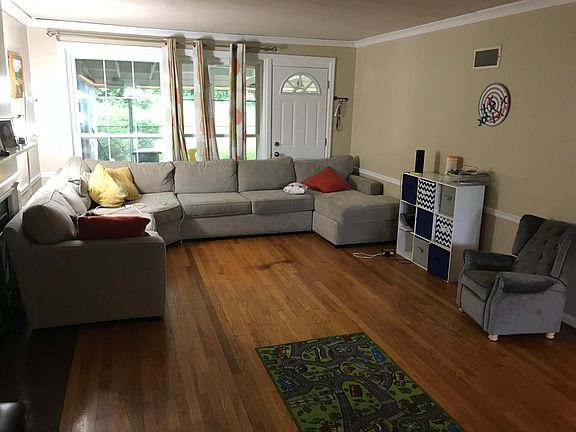 The Living Room looks out into the screen-in porch and a beautiful back yard. This furniture arrangement was chosen to block the back door and the fireplace from an unusually curious and persistent toddler.