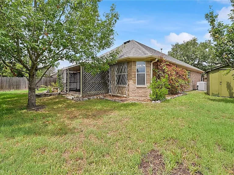 backyard with fruit bearing pear tree and storage shed