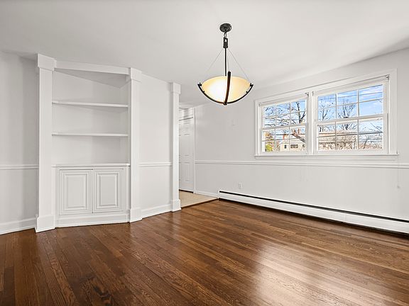 Large dining room with built-in cabinet/shelves.