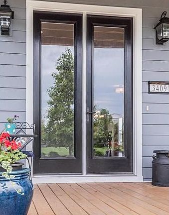Beautiful entry door trimmed in black to match the windows.  Welcome in!