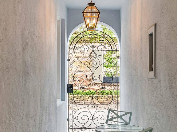 Entrance breezeway with ornate wrought iron gate.
