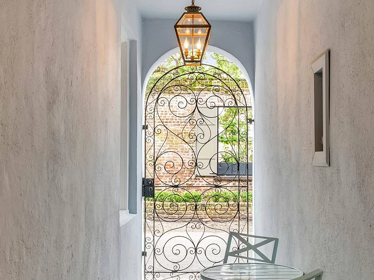 Entrance breezeway with ornate wrought iron gate.