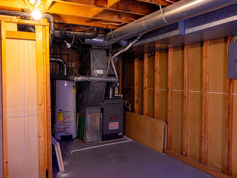 Downstairs storage room with furnace, water heater, and electrical box