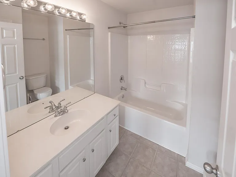 Beautiful tub and huge Hollywood mirror vanity.