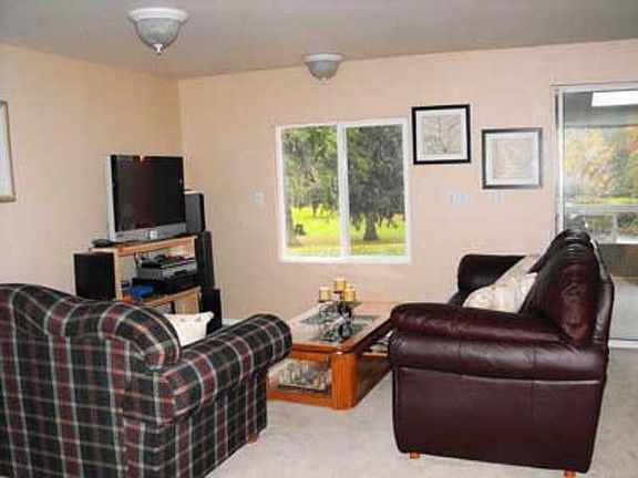 Living room with views of the river and sunroom!