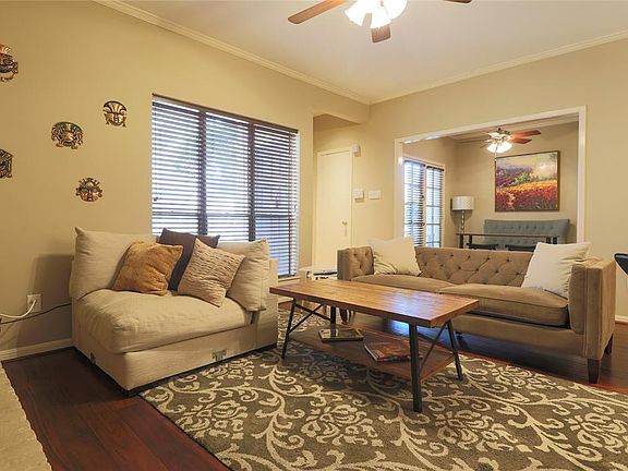 Living room with wood flooring, natural light, and open to the kitchen, office and dining area. (staged photo)
