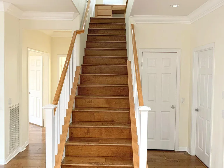 Stairs viewed from dining area. Door facing you is the coat closet. The door to the right is the laundry