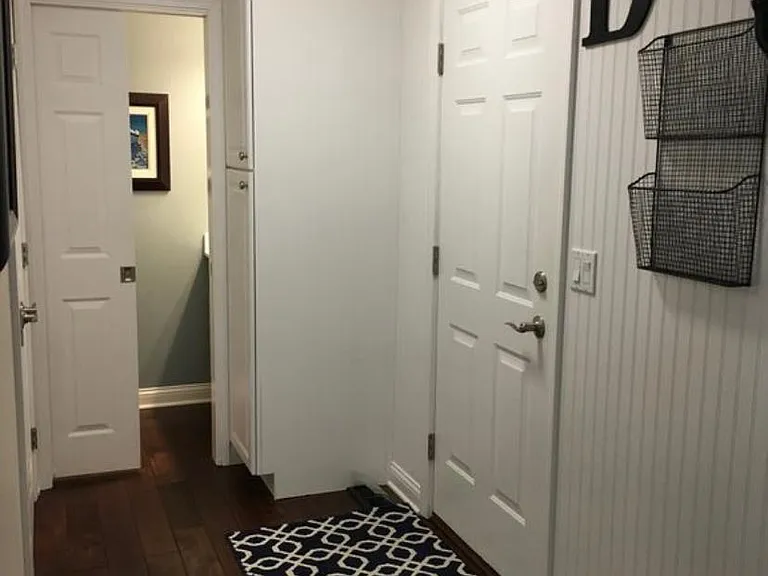 Garage entryway with washer and dryer in closet area, and half bath