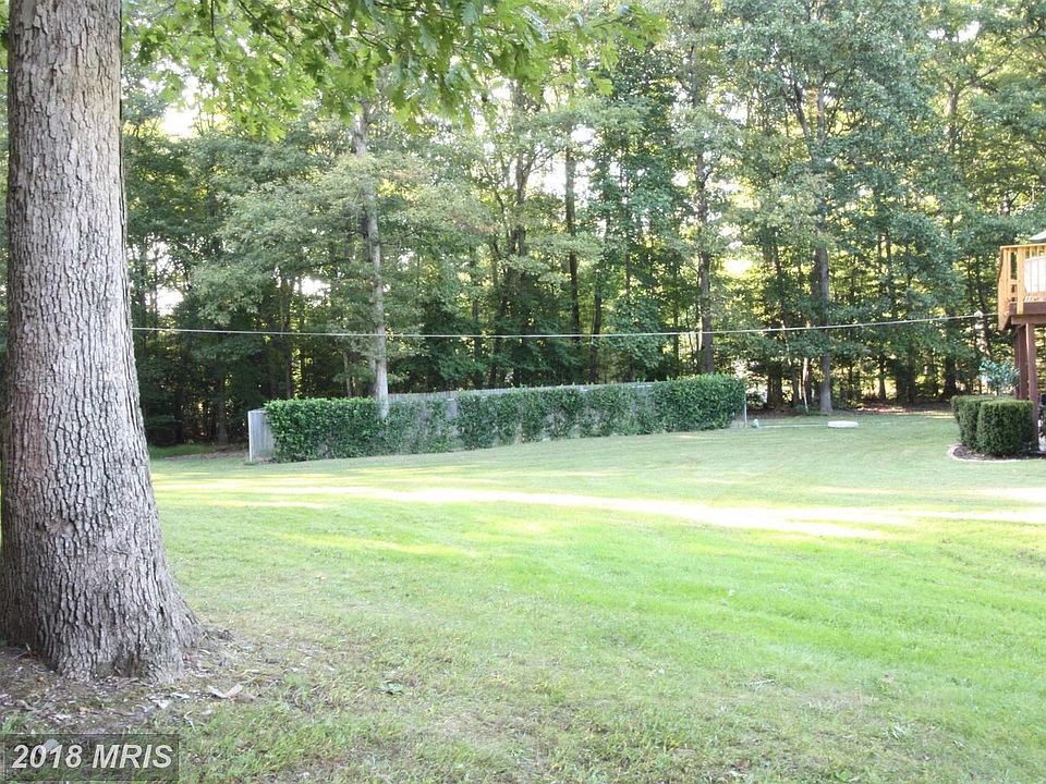 Large yard with a fenced and landscaped kennel