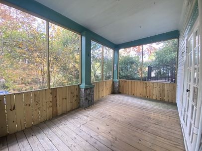 large cozy front porch that is screened in perfect for a hammock