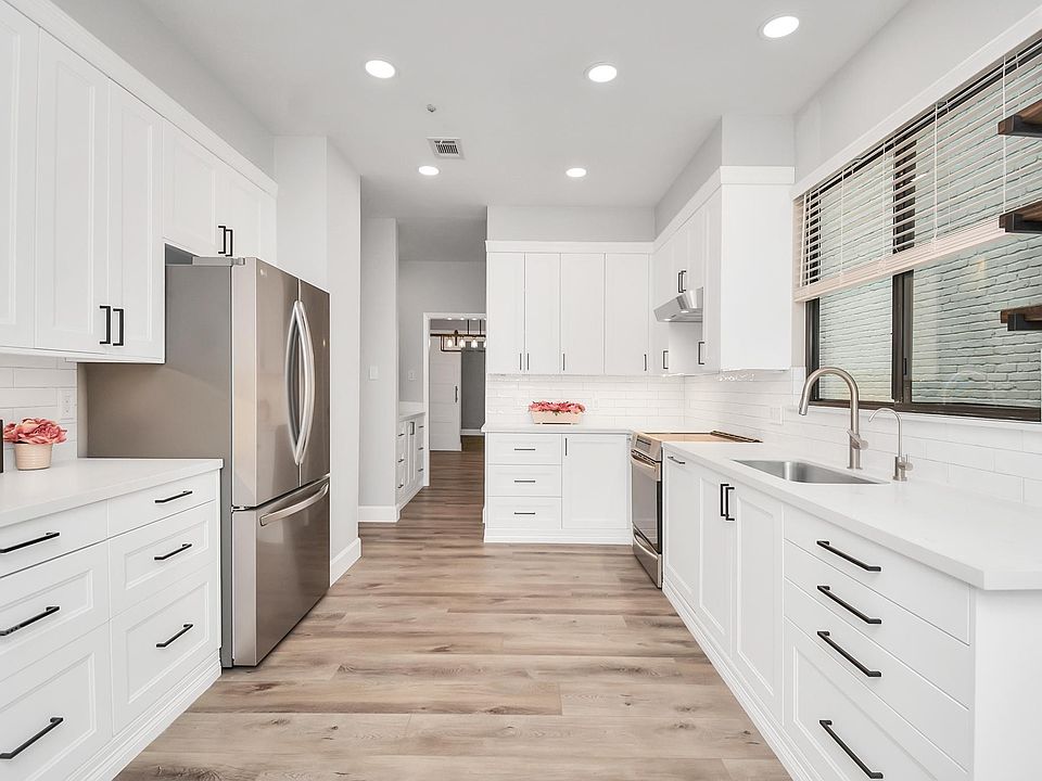 Remodeled kitchen with quartz countertops, stainless steel appliances, and under cabinet lighting.