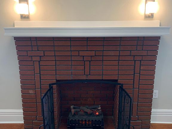 Safe electric fire logs, with choice of heat or not, has been installed in original brick fireplace and a screen added for ambiance. The mantle is a good height for a flat screen TV, and an outlet for it is nearby.