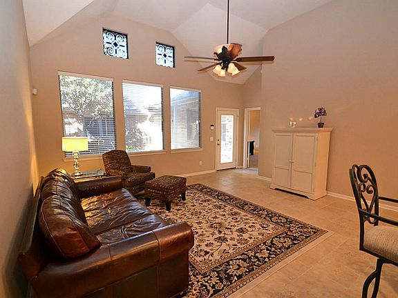 Spacious family room featuring high ceilings, ceiling fan with light fixture, open to the kitchen an