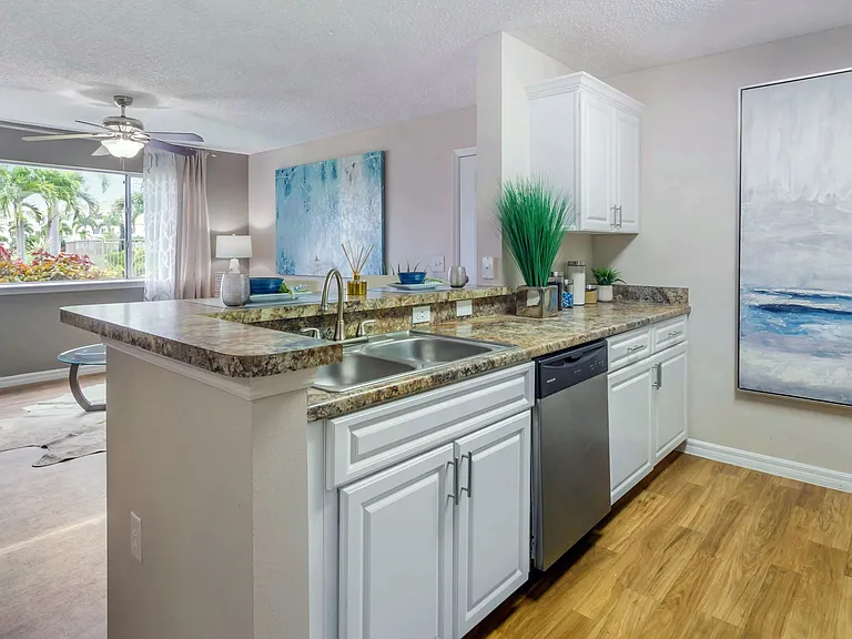 Discover the warmth and charm of Lexington Palms' golden Mascarella kitchen countertops paired with bright white cabinetry and contemporary stainless steel finishes.