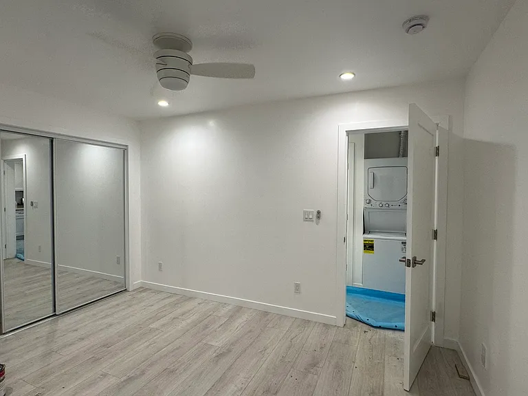 Primary bedroom with fan, mirrored closet and attached private bath.