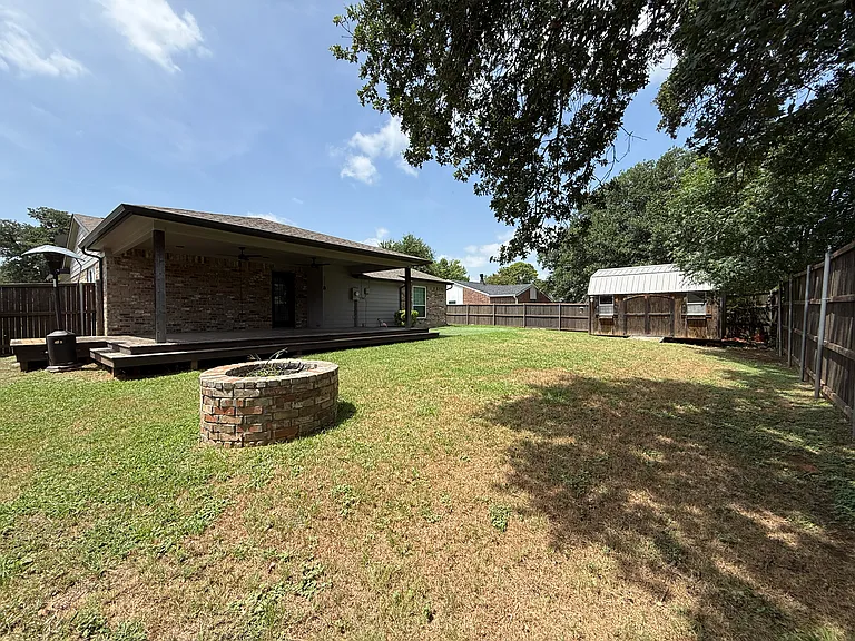 Backyard with Covered Deck, Fire Pit, and Outdoor Shed