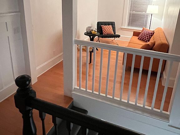 Nighttime photo of central hall, entry stairs and cozy living room.