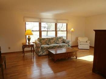 Crown molding in this large living room is complemented by beautiful hardwood flooring.