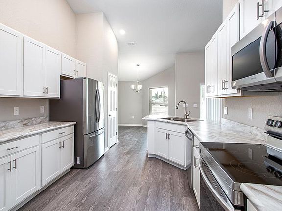 Open kitchen with 36 in. shaker-style white cabinets and stainless steel appliances - New home for s
