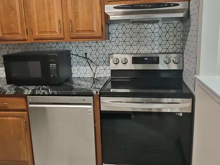 Dishwasher, microwave, Cooking range and hood that vents to outside.