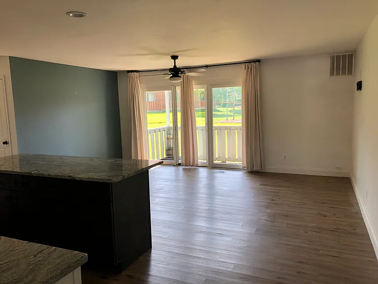 living room with ceiling fan, TV mount and new Pella sliding glass door with roll screen
