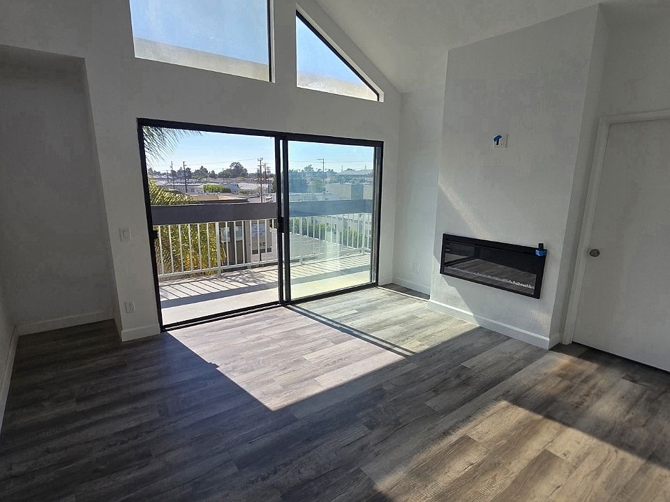 Spacious vaulted ceiling living room opens to newly renovated balcony.