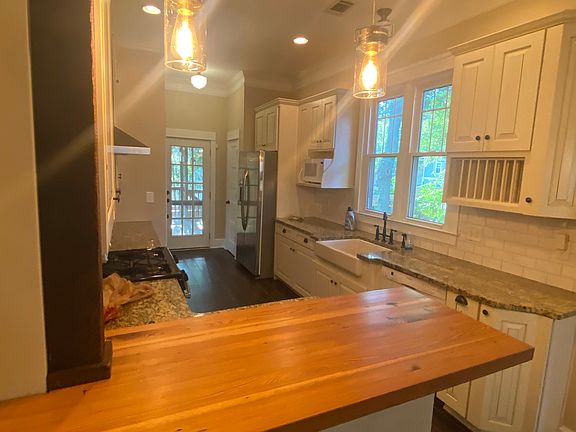 Opposite view of kitchen with seated counter space. Back door to deck.