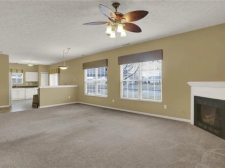 The living room carpet floor has been replaced to light grey hardwood.
