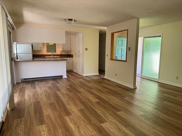 Large open living, dining, and kitchen area. New wood look vinyl flooring