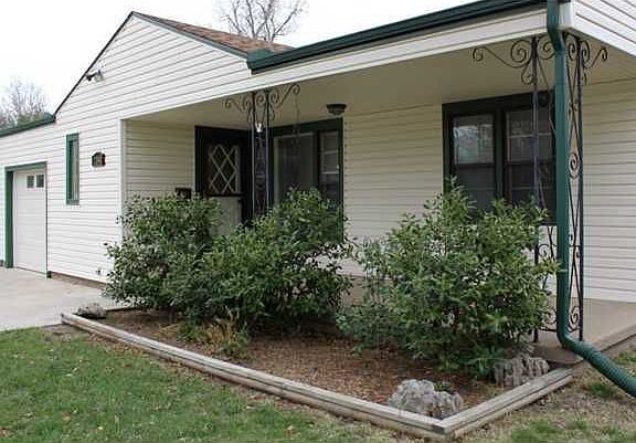 ENJOY THE WARM GREETING THIS COVERED PORCH PRESENTS