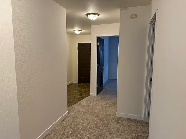 View of front door on the left, extra bedroom in middle, and main bathroom on right