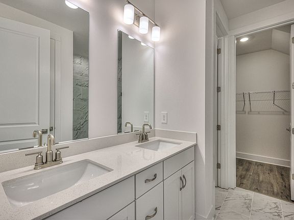 The primary bathroom offers dual vanity sinks and a walk-in closet.