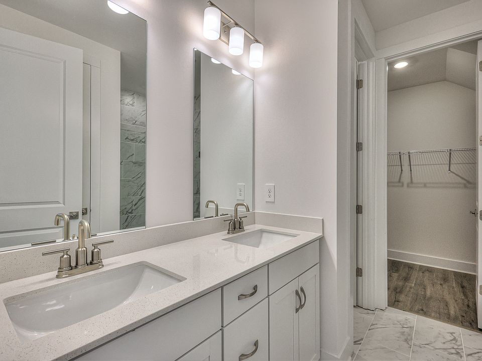 The primary bathroom offers dual vanity sinks and a walk-in closet.