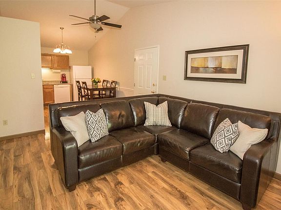 View from living room to entrance on the right, kitchen straight ahead and hallway to bedrooms on the left. Very open with beautiful ceiling fan and lights. Soft, neutral colors.