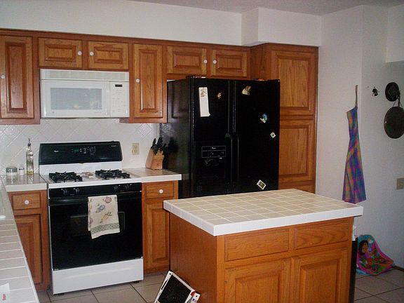 Kitchen has tile counters/backsplash