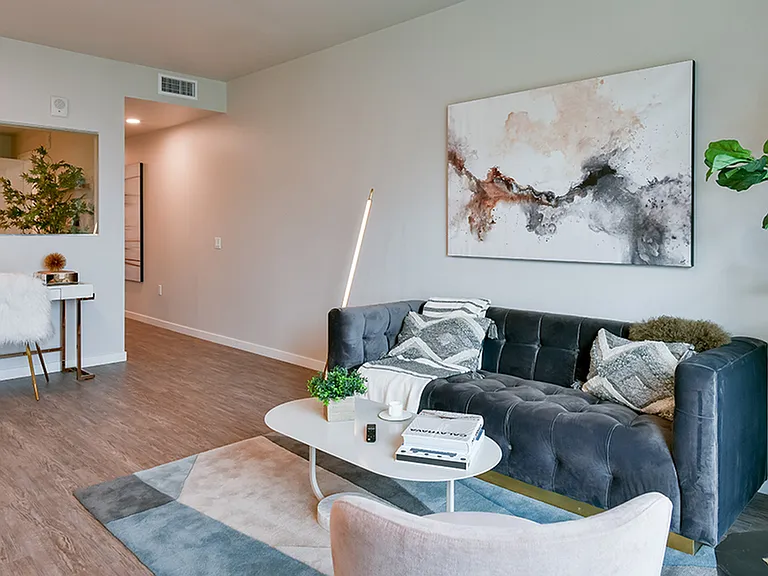 Spacious light-filled living room with wood plank-style flooring