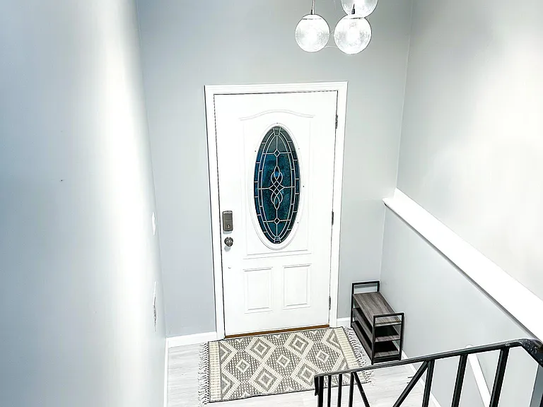 Front door with stairs leading to the main floor and to the basement and garage.