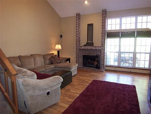 Great Room is enhanced with 2-story vaulted ceilings, laminate wood floors, brick fireplace & tons of windows provide natural light.