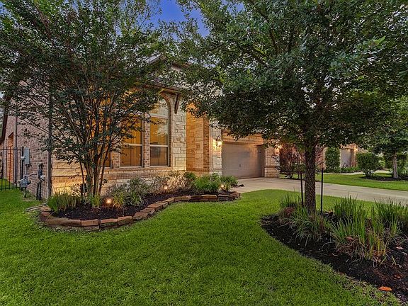 Maturing trees, lush landscape and lighting create a lovely environment in the front and back of home.